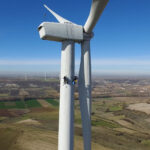 imagen desde dron de dos operarios trabajando en un aereogenerador