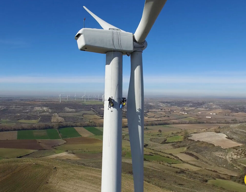 imagen desde dron de dos operarios trabajando en un aereogenerador
