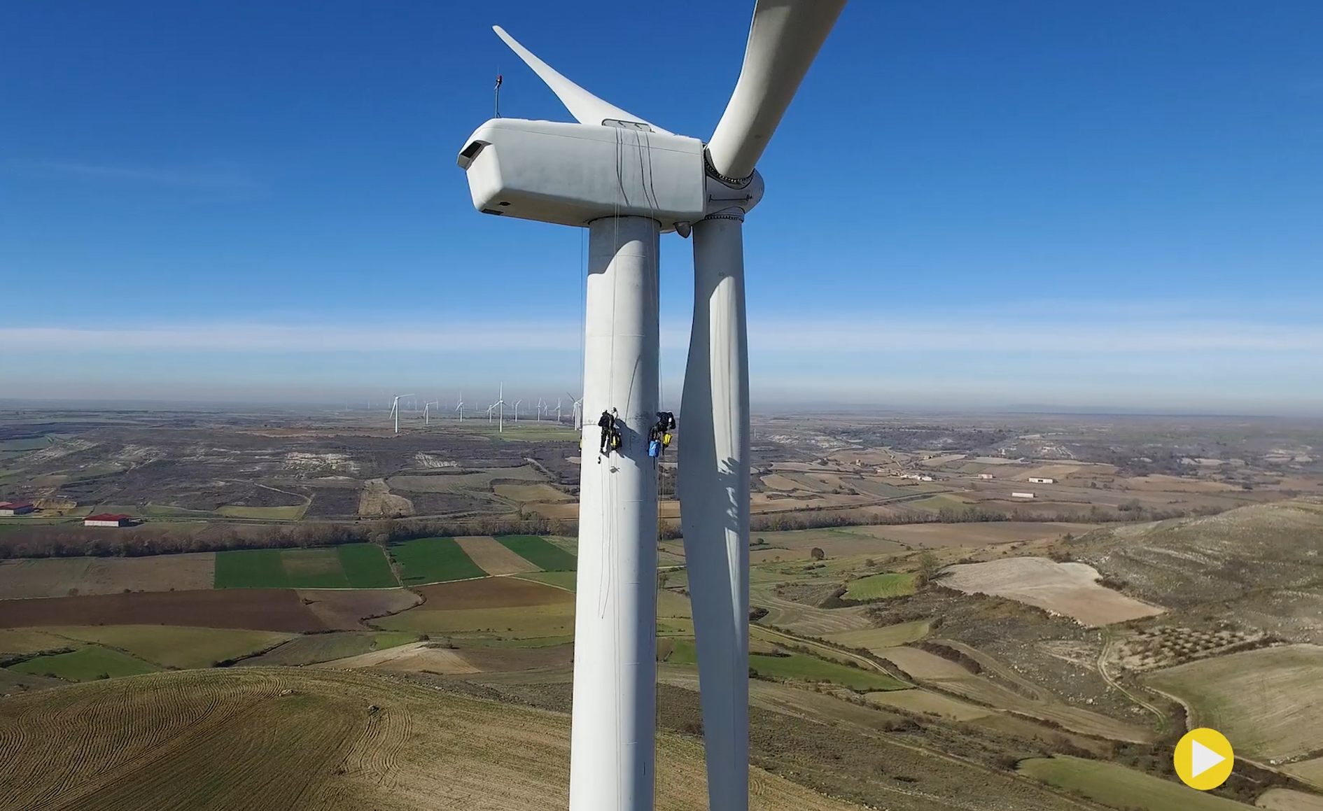 imagen desde dron de dos operarios trabajando en un aereogenerador